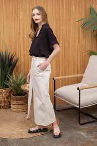 Woman in a black top and beige skirt showcasing a Striped Collared Split Neck Blouse