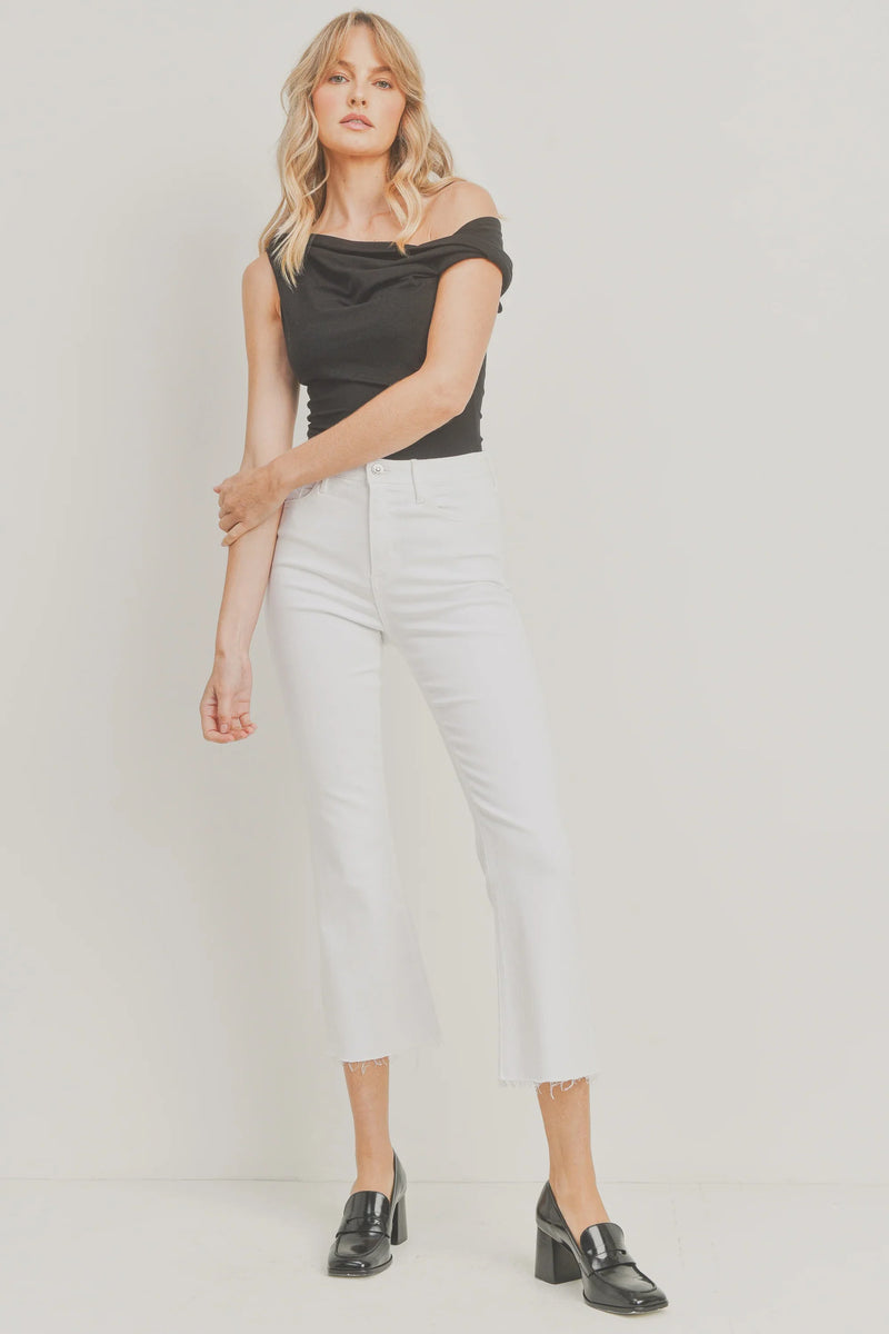 Woman wearing a black off-shoulder top with white cropped demi flare pants