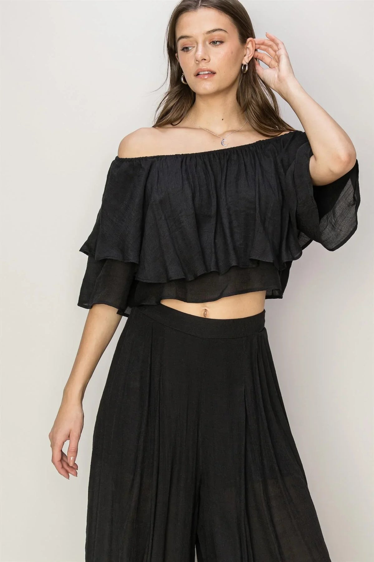 Woman in a black palazzo pants set with flowy silhouette for summer wardrobe