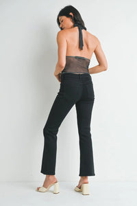 Woman in black pants and backless top showcasing Petite Bootcut Denim Jeans