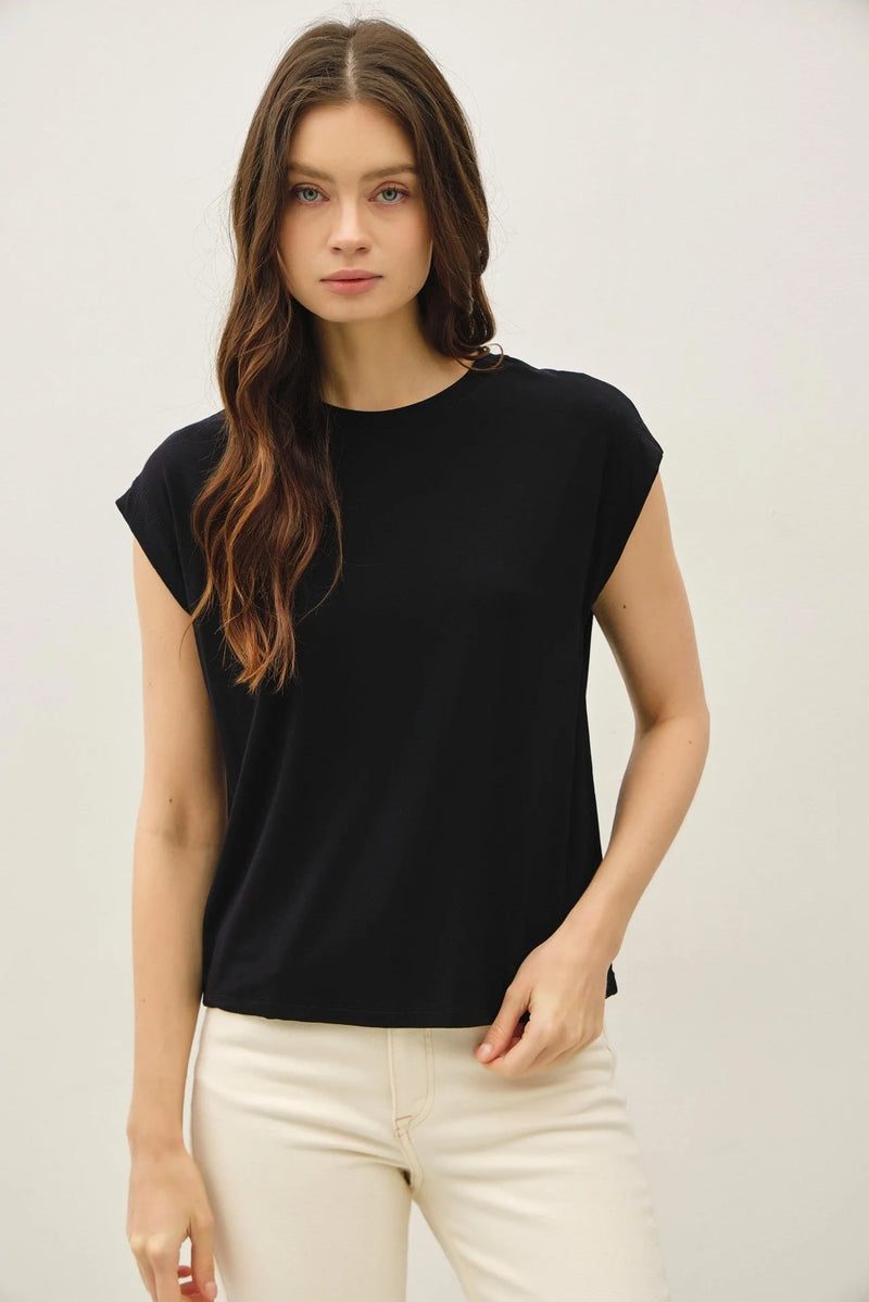 Woman wearing black bamboo cap sleeve basic round neck top and light-colored pants