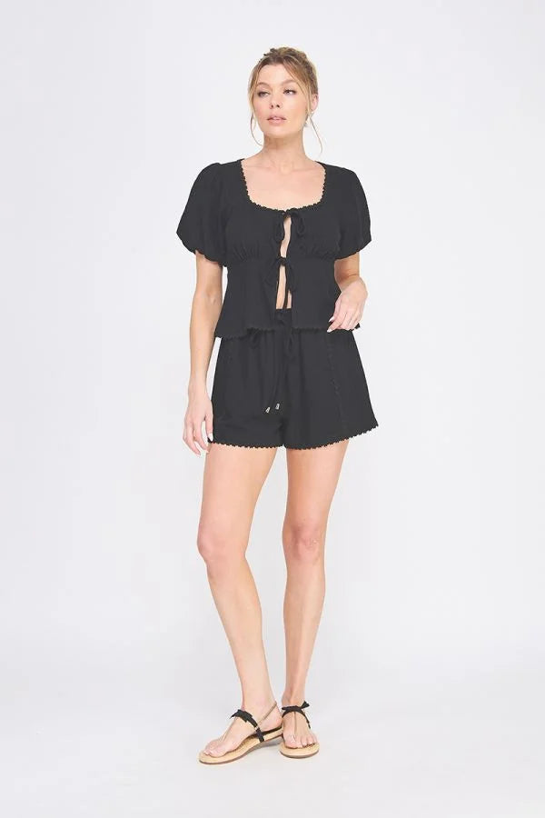 Woman wearing linen blend puff short sleeve top and shorts, stylish summer outfit