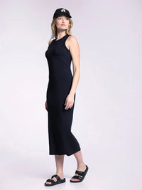 Woman in a black muscle tank fitted midi dress and baseball cap, showcasing stylish elegance