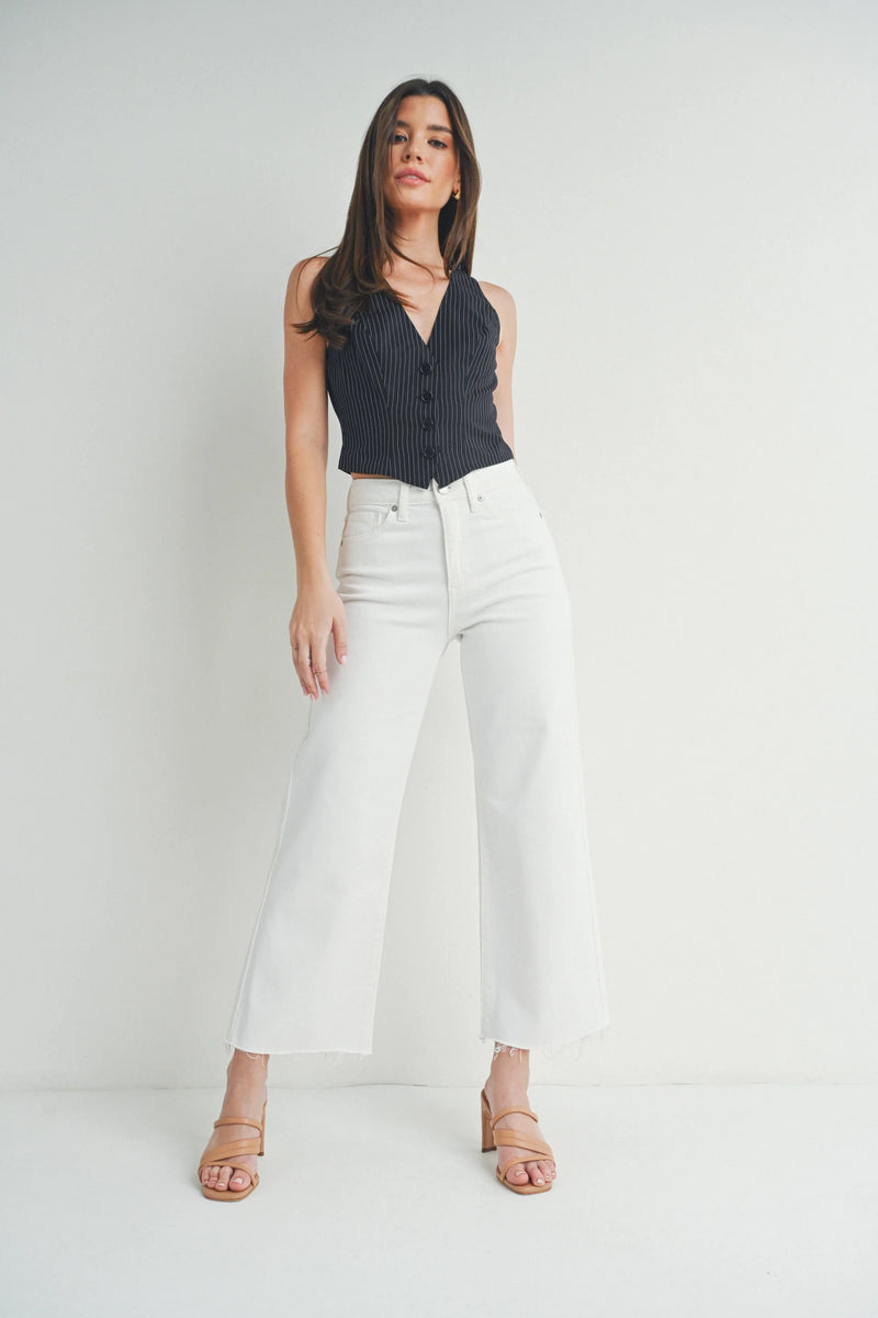 Woman in a black sleeveless top and white wide leg pants from Slim Wide Leg collection