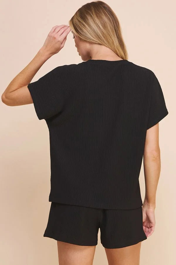 Woman in a black EASY TEXTURED KNIT TOP and shorts, viewed from behind