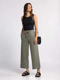 Woman in a black tank top and olive green wide-leg pants featuring Edlin Basic Tank