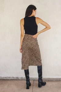 Woman in black tank top paired with a size small animal print midi skirt