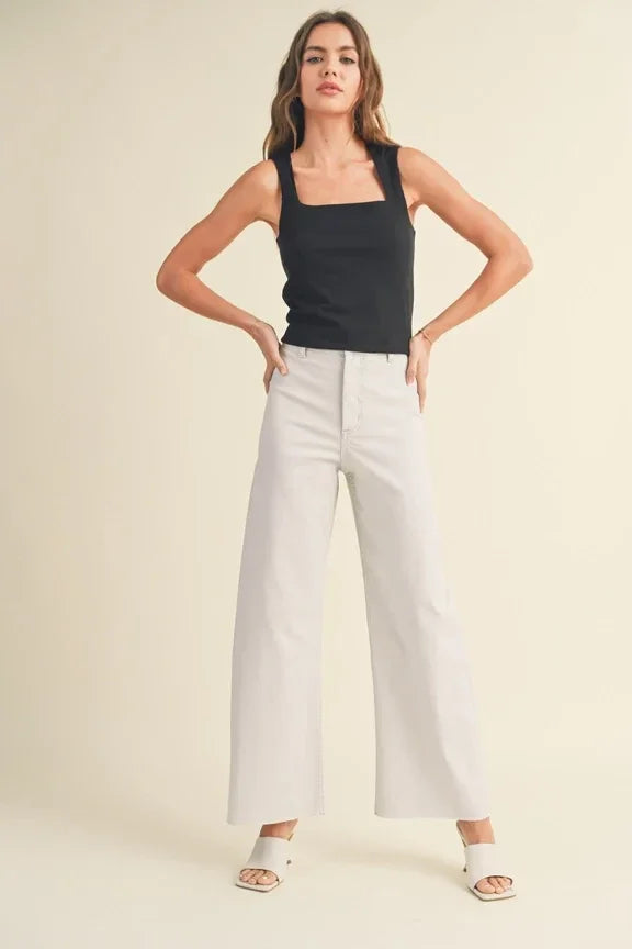 Woman in black tank top and white wide-leg pants showcasing Mini Ribbed Squared Neck