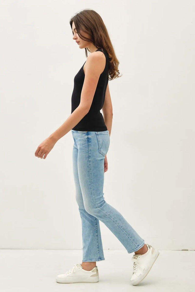 Woman in black tank top and light blue jeans wearing MINIMAL V NECK SWEATER TANK for women’s boho chic clothing at Shop Daisy