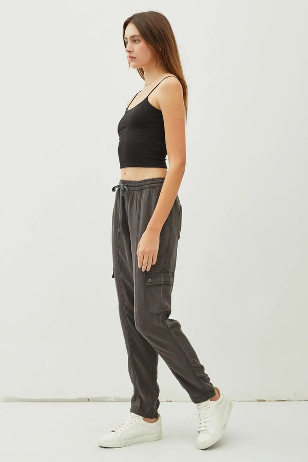 Woman in a black tank top and gray TENCEL cargo utility pants showcasing style and comfort