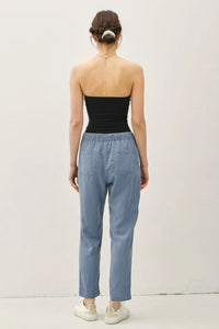 Woman wearing black tube top and blue TENCEL TAPERED PANTS for a stylish look