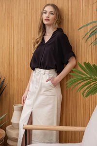 Woman in black top and white skirt showcasing a Striped Collared Split Neck Blouse