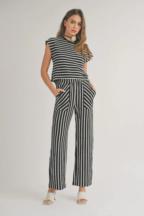 Woman in a black and white striped jumpsuit showcasing a textured stripe knitted design