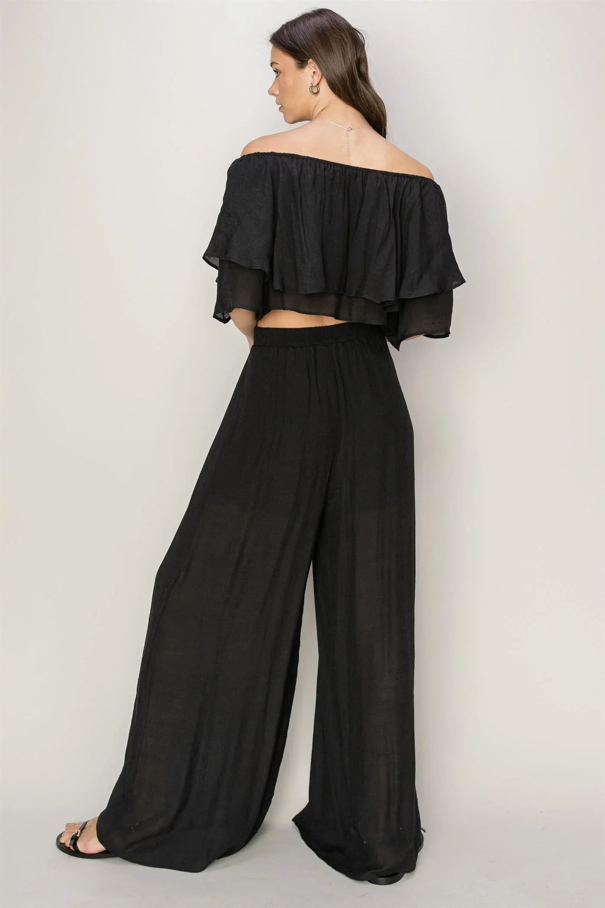 Woman in a black off shoulder top and palazzo pants set for a flowy summer wardrobe