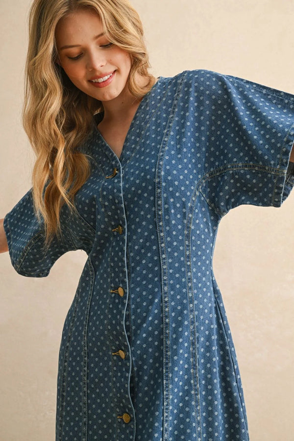 Woman wearing a blue dot print boho chic dress with button front and short wide sleeves