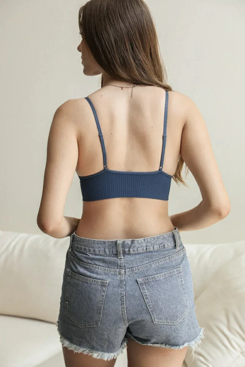 Woman in a blue top and denim shorts showcasing Waistband Loop Lace Seamless Brami Bralette