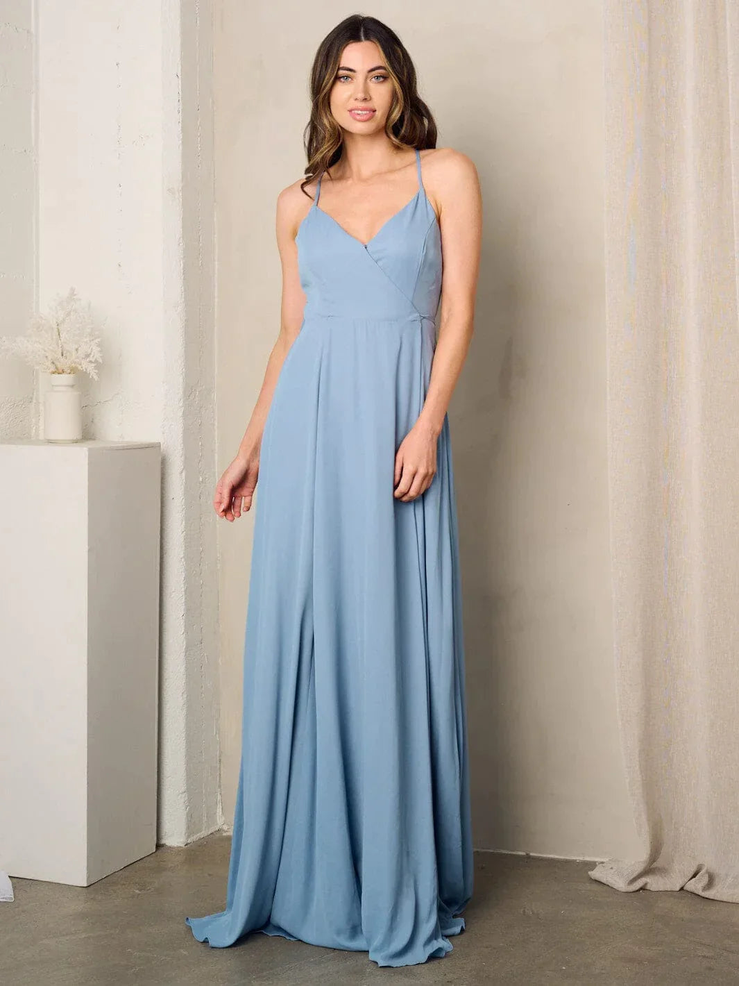 Woman in a blue sleeveless surplice tie maxi dress showcasing elegant style and comfort