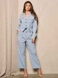 Woman in a blue long sleeve button wide leg jumpsuit with white shirt and black heels