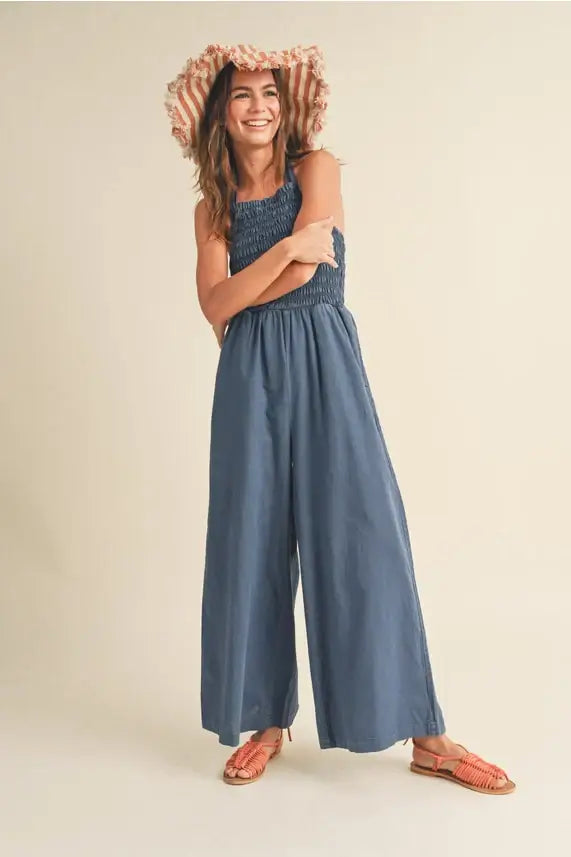 Woman in blue jumpsuit and floppy hat modeling Women’s Boho Chic Clothing from Shop Daisy