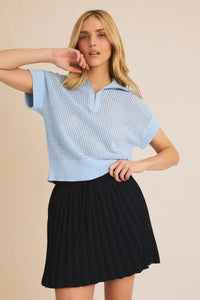 Woman in a blue knit top and black skirt from Shop Daisy’s women’s boho chic clothing