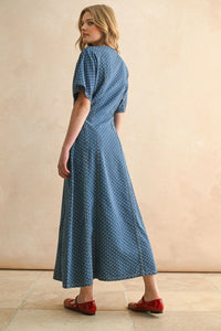 Woman wearing a blue dot print midi dress with red flats, perfect for women’s boho chic clothing at Shop Daisy