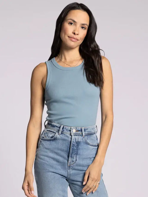 Woman wearing THREAD & SUPPLY EVIE TANK in blue ribbed tank top and jeans