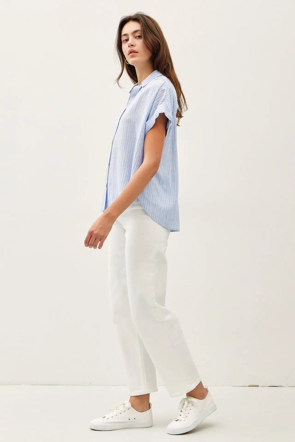 Woman in blue striped shoulder shirring top, perfect for women’s boho chic clothing at Shop Daisy
