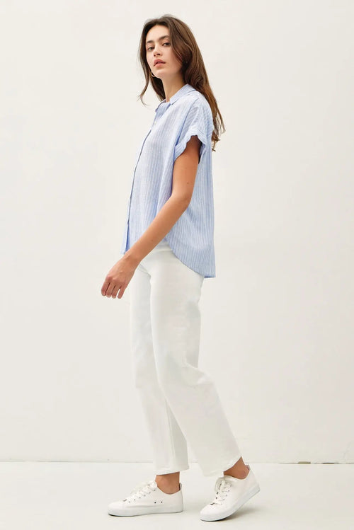 Woman in blue striped shoulder shirring top, perfect for women’s boho chic clothing at Shop Daisy