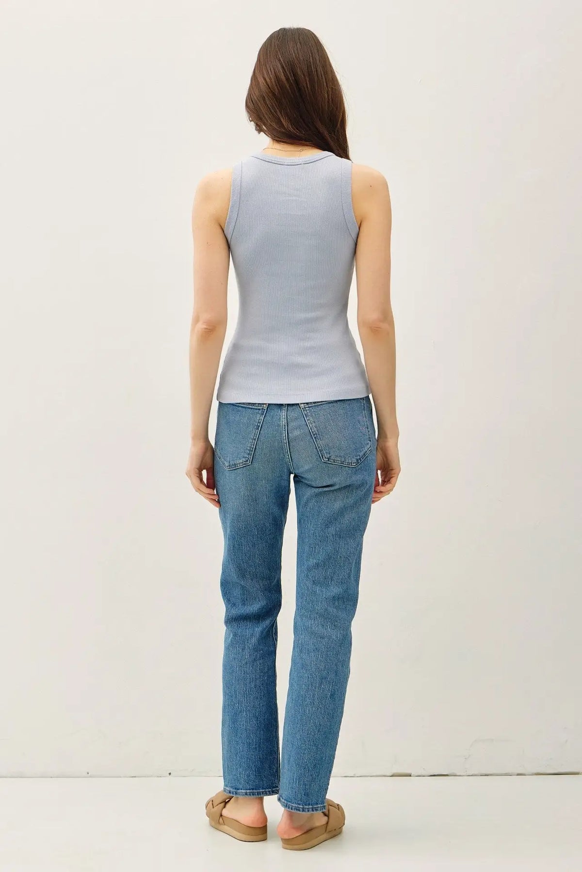Woman wearing a dyed round neck tank top in blue with jeans for a casual look