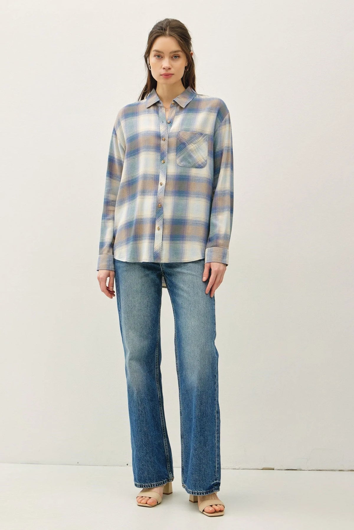 Woman wearing a vintage plaid boxy shirt in blue and white plaid with blue jeans