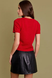 Woman in red short-sleeved top and black leather skirt showcasing women’s boho chic clothing