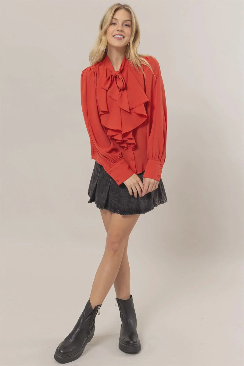 Woman in a red ruffled blouse and mini skirt showcasing women’s boho chic clothing