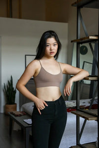 Woman in a brown top and black pants wearing a seamless bralette for an effortlessly chic look