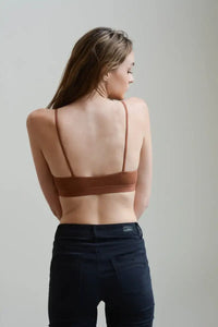 Woman wearing a horizontal strap bralette paired with black jeans in a stylish look