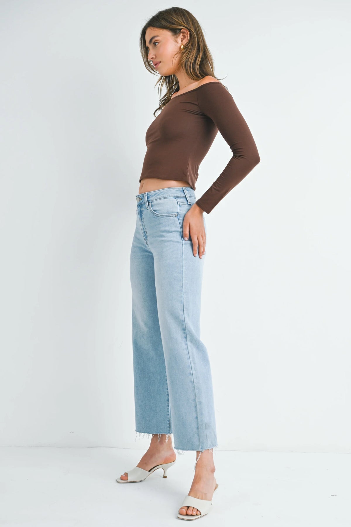 Woman in a brown crop top and light blue jeans embodies boho free spirit style