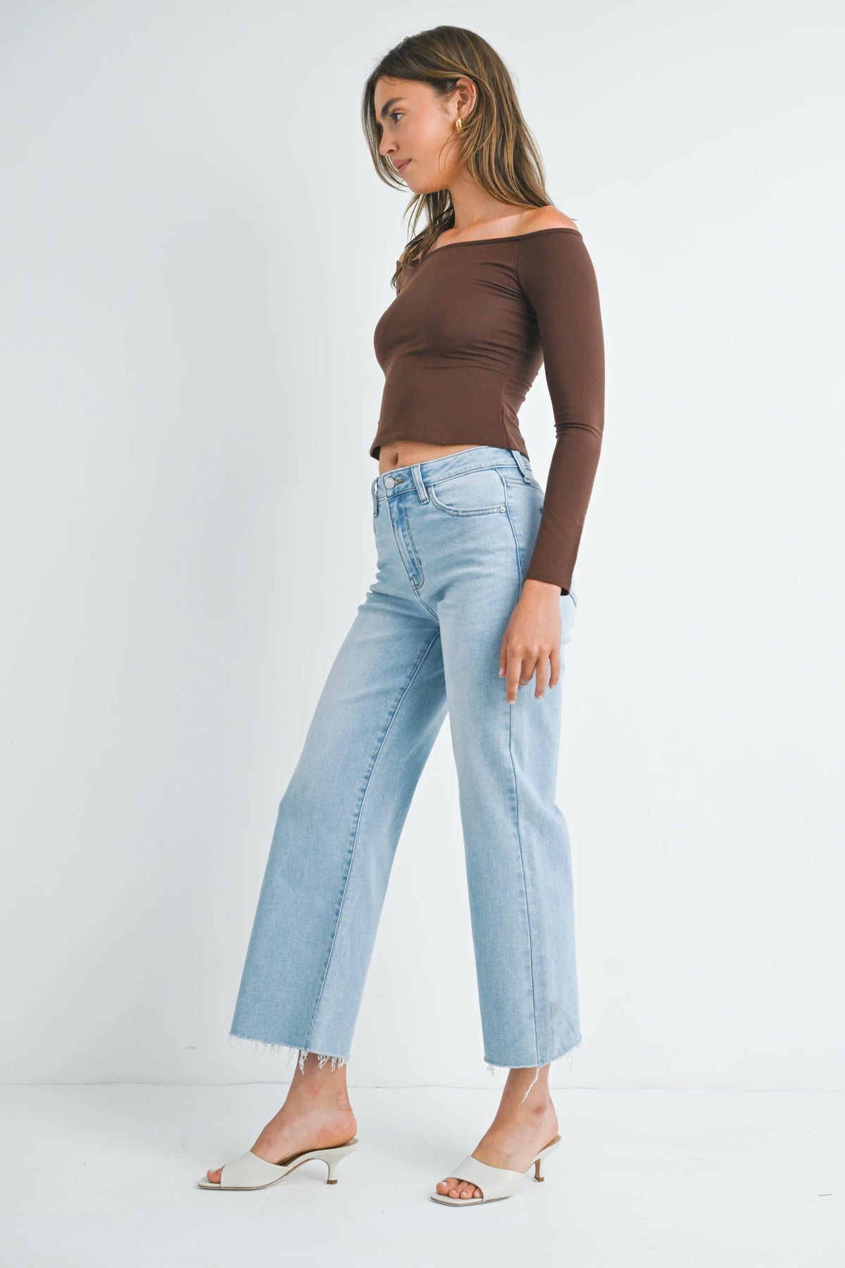 Woman in a boho off-shoulder top and light blue jeans styled with SLIM WIDE LEG DENIM