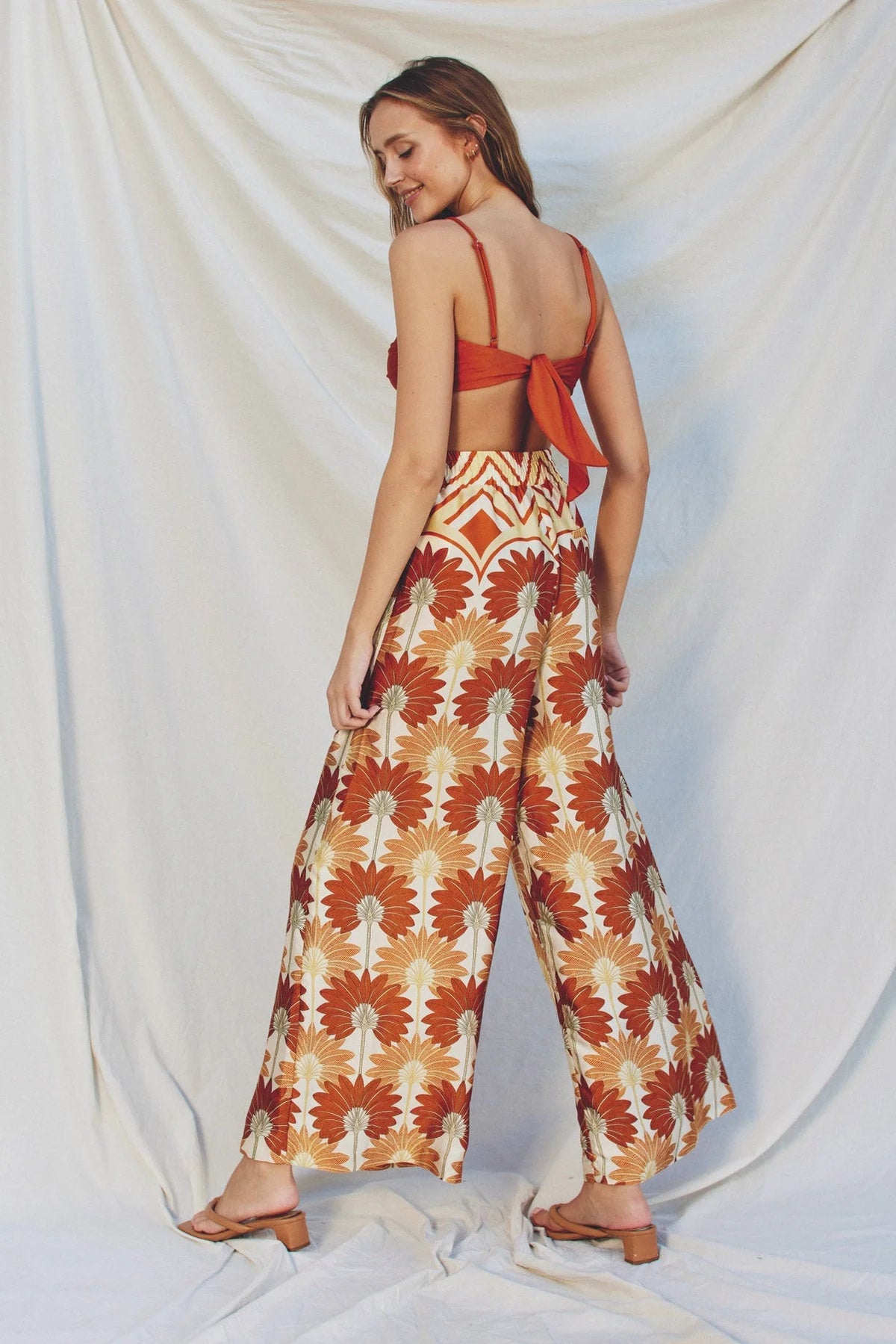 Woman modeling GOLDEN AGE WIDE LEG PULL ON PANTS in brown and orange bohemian wide leg style