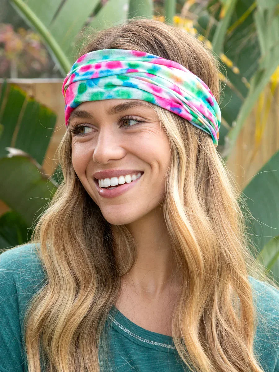 Smiling woman in teal top and colorful boho headband, embodying a free spirit style