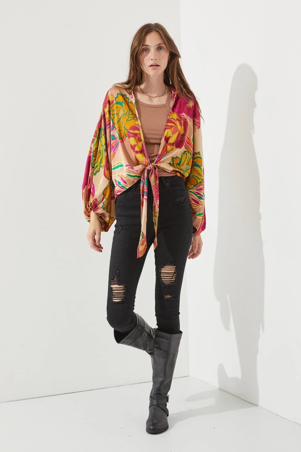 Woman in a colorful shirt and black jeans showcasing a Floral Print Tie-Front Cardigan