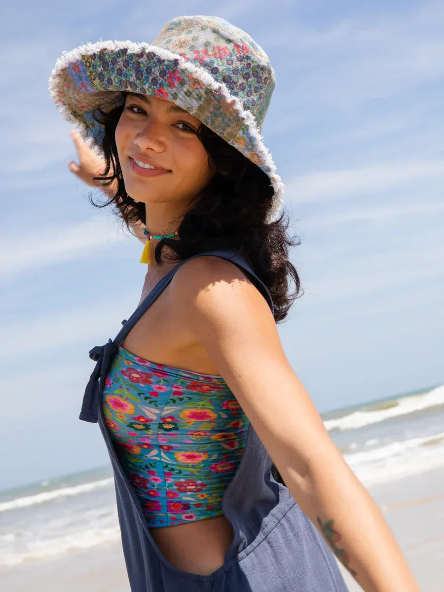 Woman in colorful sun hat and beach attire, embodying boho free spirit style