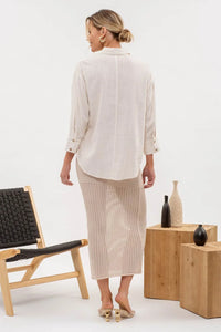 Woman in cream stripe button down shirt and long skirt, showcasing bohemian style