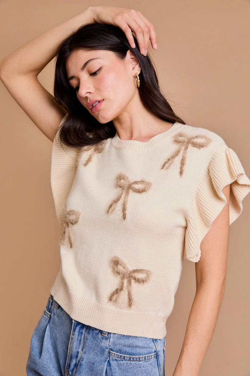 Woman in cream ruffle sleeve bow top from Shop Daisy, premium women’s boho chic clothing