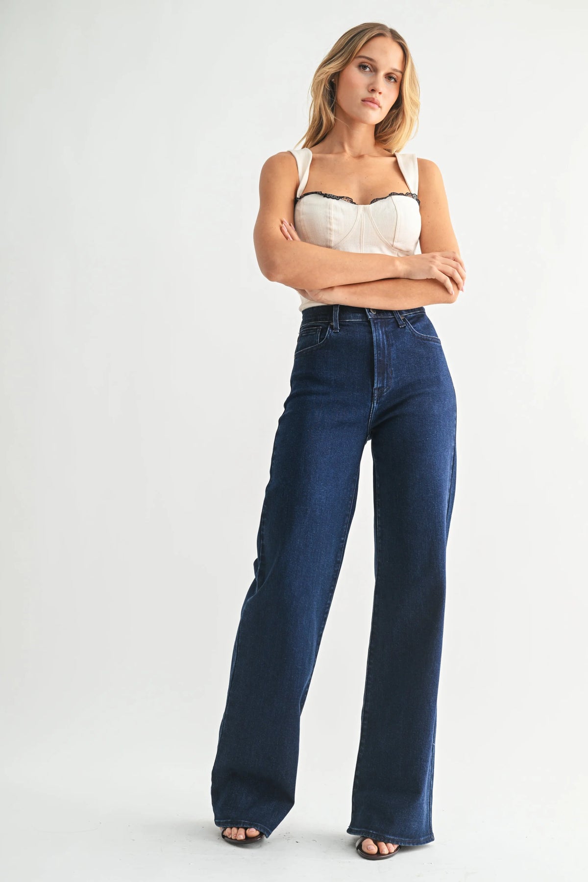 Woman wearing high rise wide leg palazzo denim jeans with cream top and dark trim