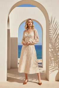Woman wearing a cream lace jacquard maxi dress with midi skirt and brown heels