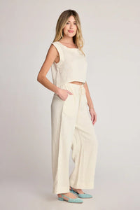 Woman wearing cream-colored linen top and pants from SUNDAY RITUAL DAHLIA PANTS, ideal for women’s boho chic clothing