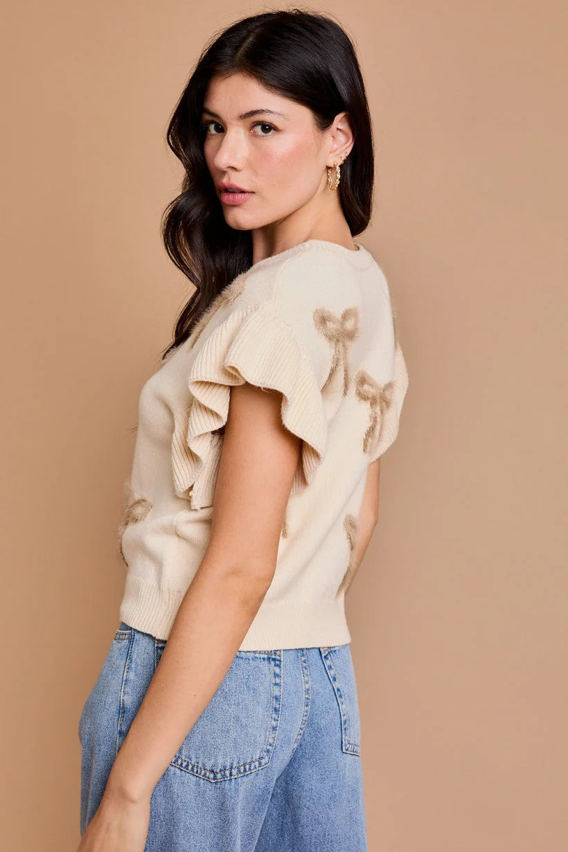 Woman in cream ruffled top and blue jeans from Shop Daisy’s women’s boho chic clothing