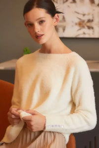 Woman in a cream-colored sweater from Shop Daisy, ideal for women’s boho chic clothing