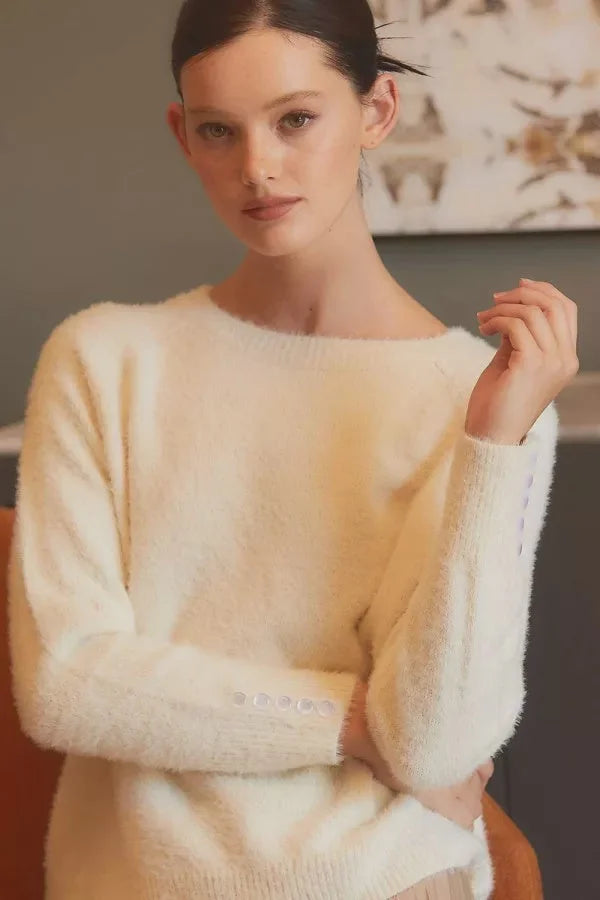 Woman in cream sweater, showcasing women’s boho chic clothing from Shop Daisy