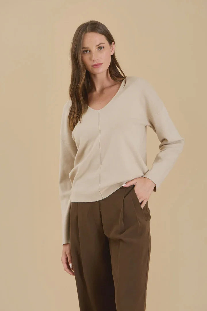 Woman in a cream-colored Seam Knit Sweater with Solid V Neck and brown trousers