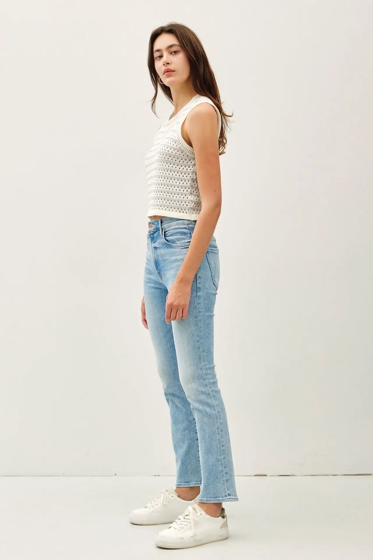 Woman wearing a chunky knit striped sweater tank with jeans, perfect for casual wear